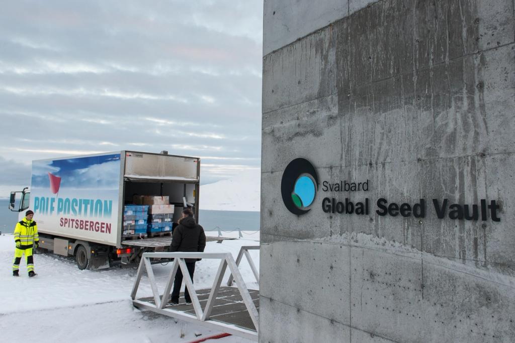 Unloading a Pole Position truck beside a concrete wall bearing the Svalbard Global Seed Vault logo