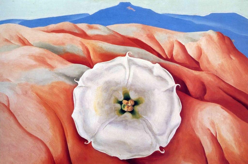 O'Keeffe painting: a white flower against red hills with a blue mountain in the distance