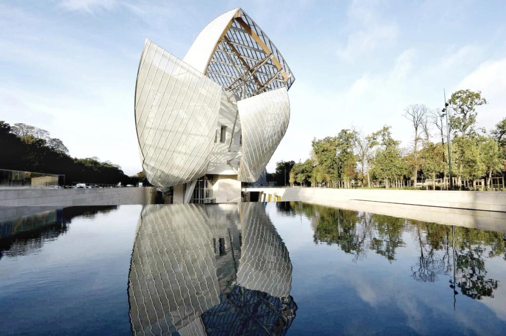 Стеклянные паруса Фонда Louis Vuitton в Париже, отражённые в водоёме среди деревьев