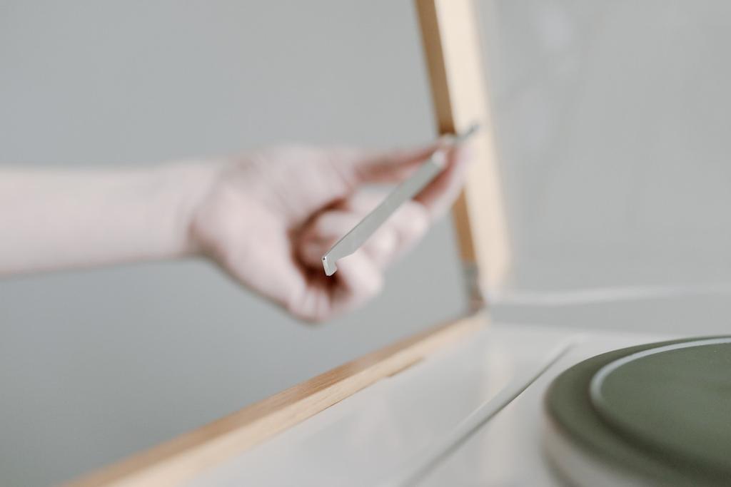 The turntable lid propped open on a slender metal support, with the platter visible below