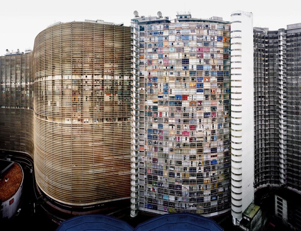 Dense high-rise development with colourful window façades beside a cylindrical building