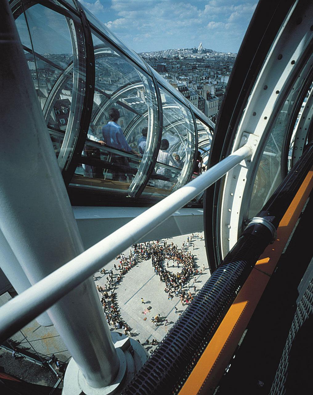 A view of Paris through the glass escalator tube of the Centre Pompidou, with the plaza below
