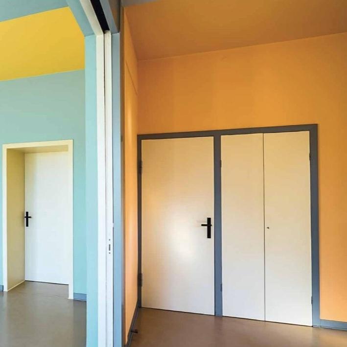 Colourful interior of Auerbach House with orange, blue and yellow walls and a double door