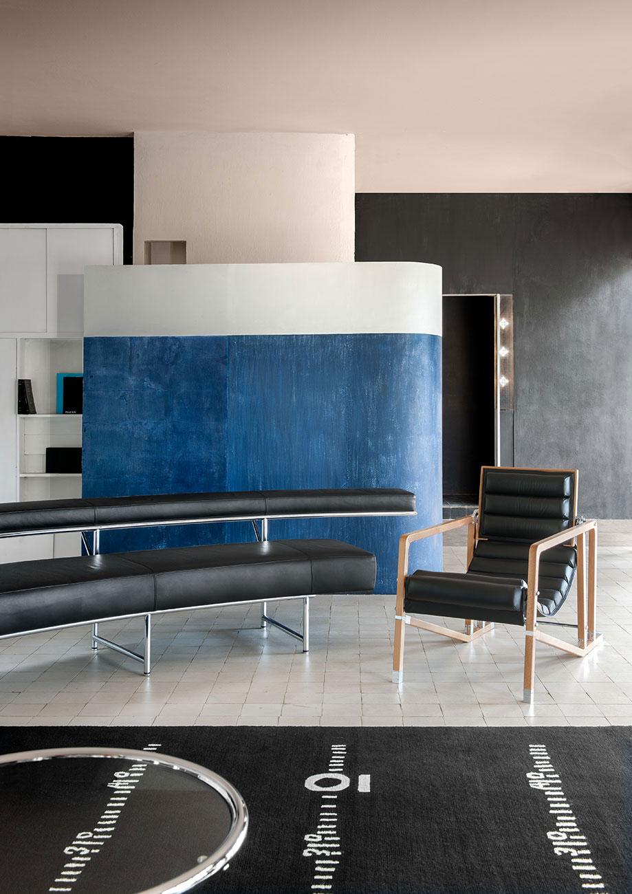 Interior of Villa E-1027: a curved white-and-blue partition, a leather bench and a Transat armchair