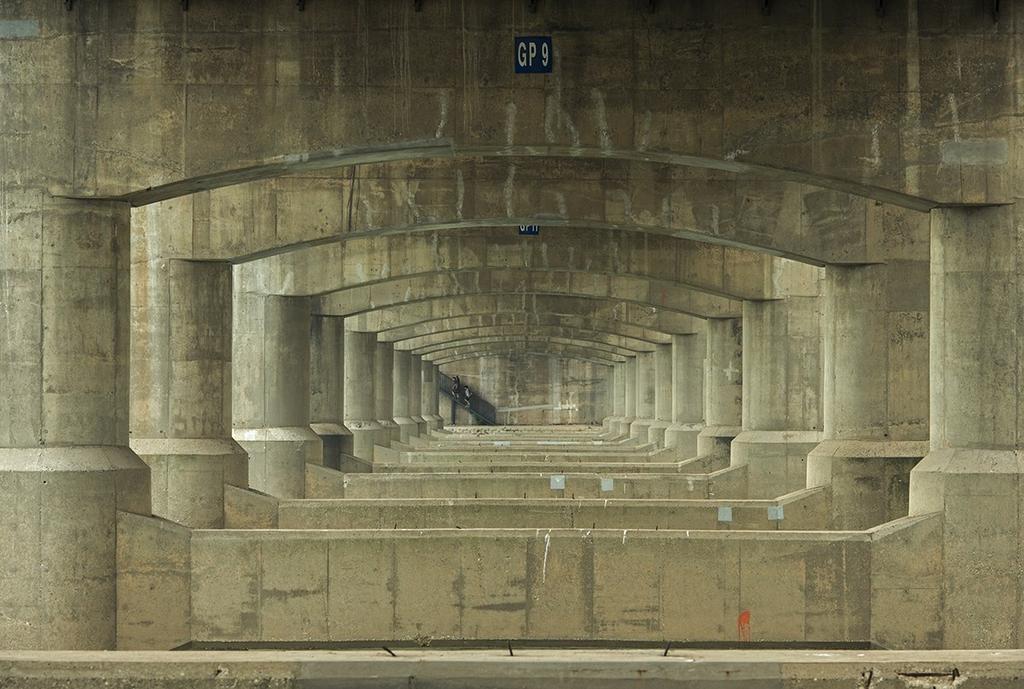 Арочные пролёты под мостом с маркировкой GP 9, симметричный коридор бетонных опор