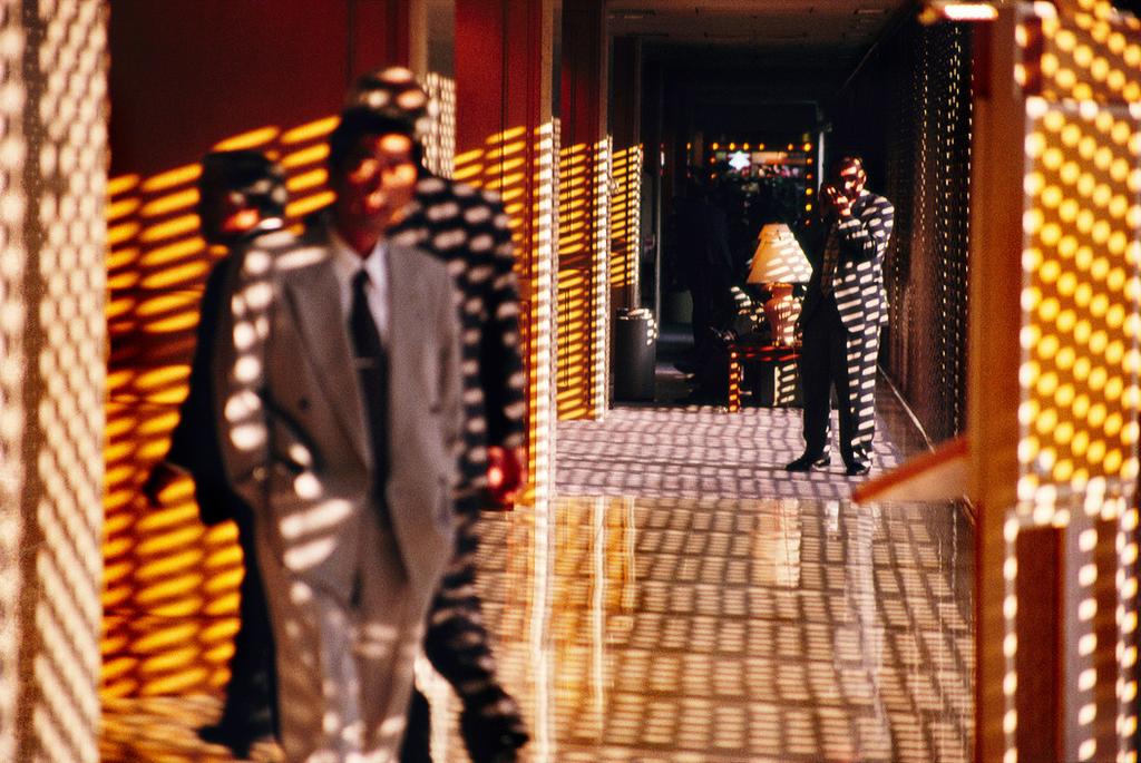 Tokyo: men in a corridor dappled with a pattern of golden light from venetian blinds