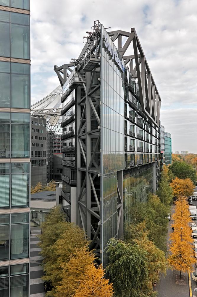The steel frame and glass body of Sony Center among autumn trees