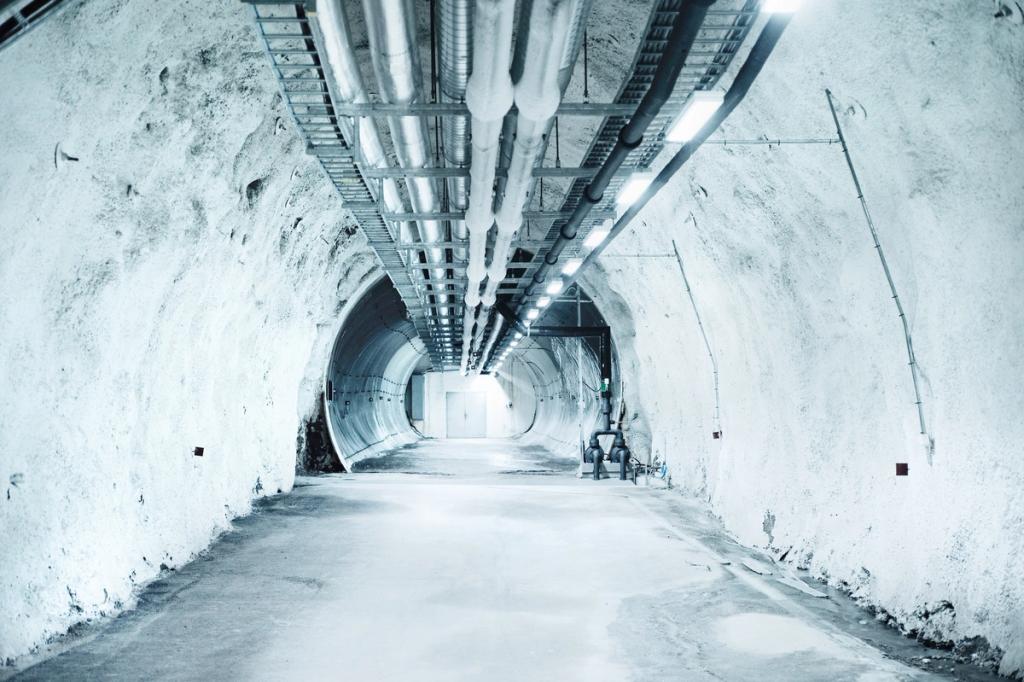 The underground tunnel of the vault with concrete arched ceilings, pipes and a row of light fixtures