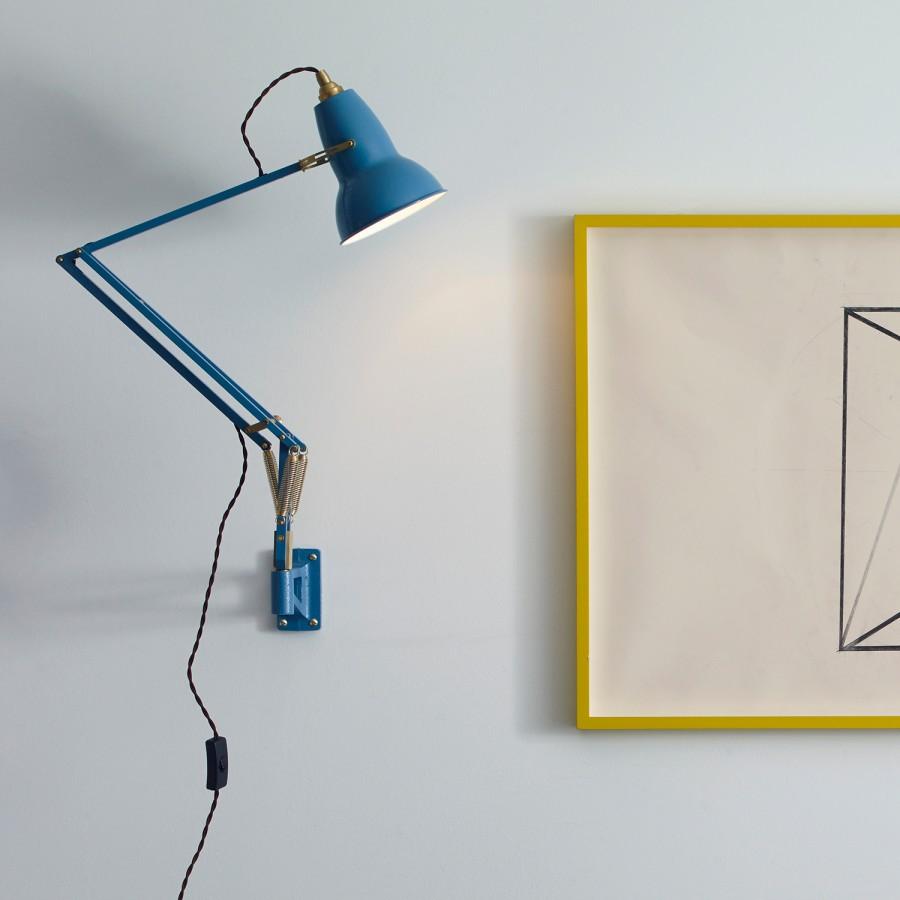 Синяя настенная лампа Anglepoise рядом с графической работой в жёлтой раме