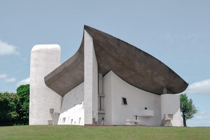 The Chapelle Notre-Dame-du-Haut with its curved dark roof and white walls on a hilltop