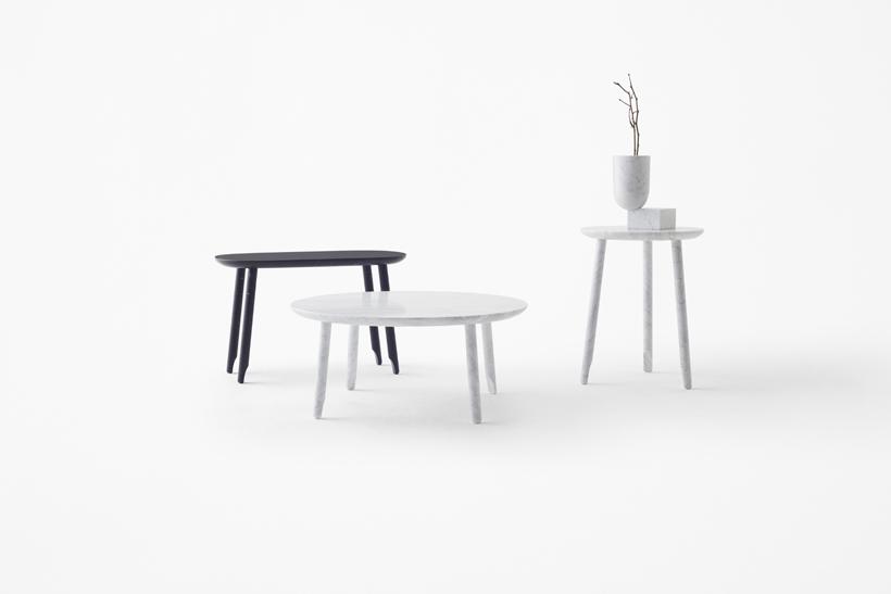 Three tables of different shapes in white and black with a vase