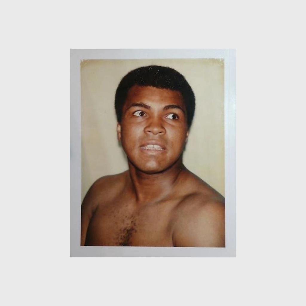 A Polaroid portrait of a bare-chested male boxer against a beige background