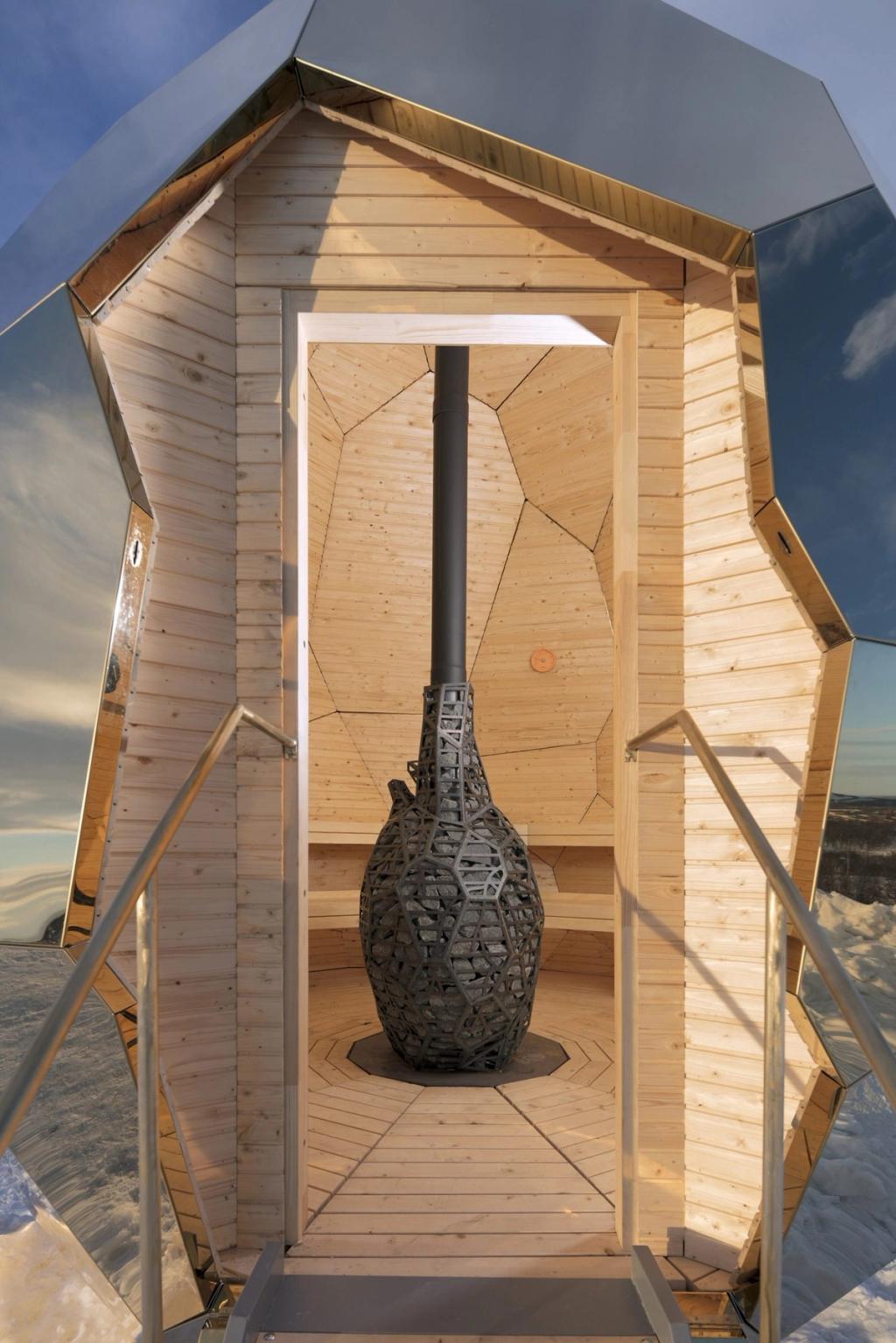 A view through the open doorway of the sauna towards the latticed stone stove inside