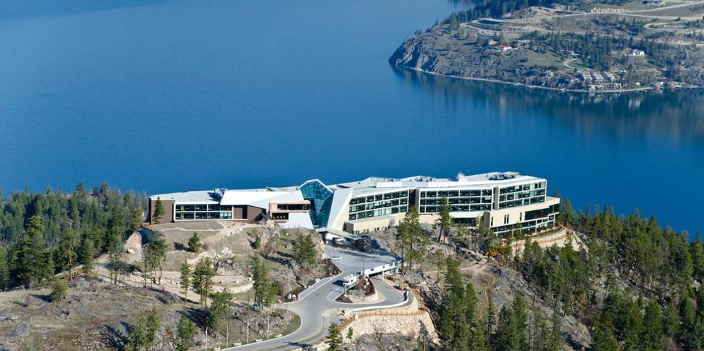 The glass building of Sparkling Hill Resort perched on a cliff above Okanagan Lake in Canada