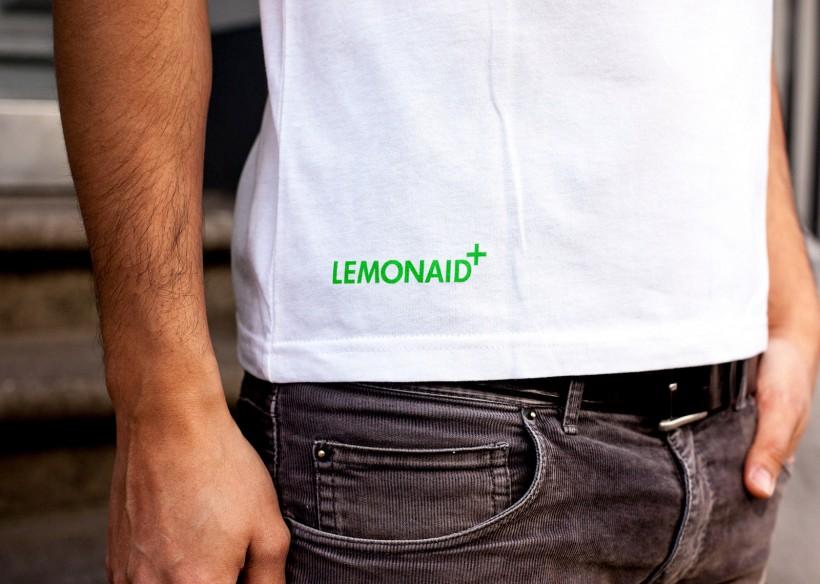 Зелёный логотип Lemonaid на белой футболке мужчины в джинсах