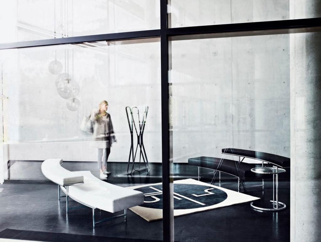 A white Lota sofa with black lacquered sides and a dark rug in a contemporary interior