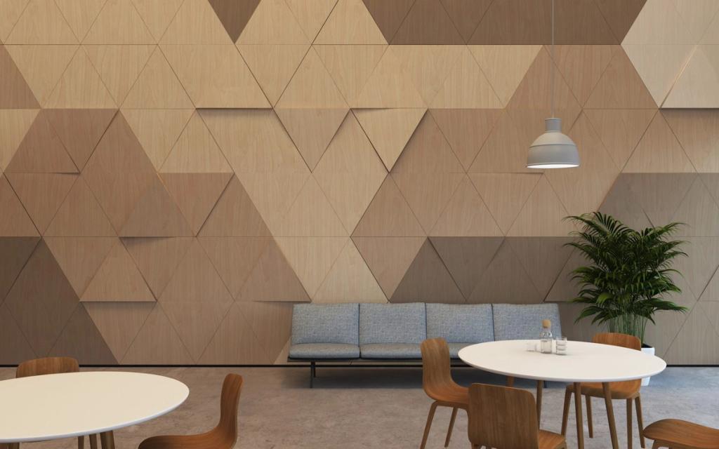 A café interior with a wall of wooden triangular tiles and round tables with wooden chairs