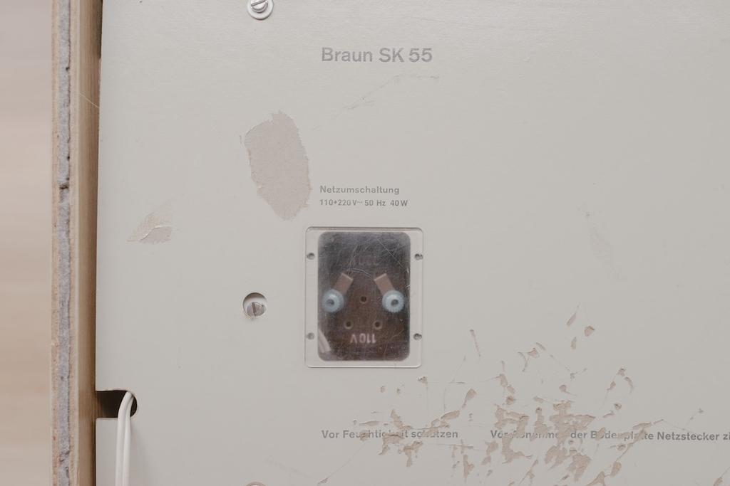 Close-up of the rear panel with the Braun SK 55 inscription and a 110–220 V voltage selector switch