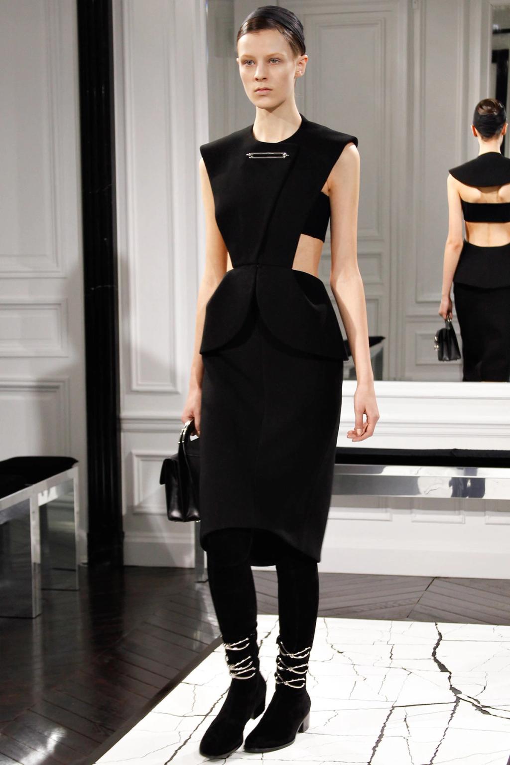 A black Balenciaga dress with a pin and waist cut-outs on the runway