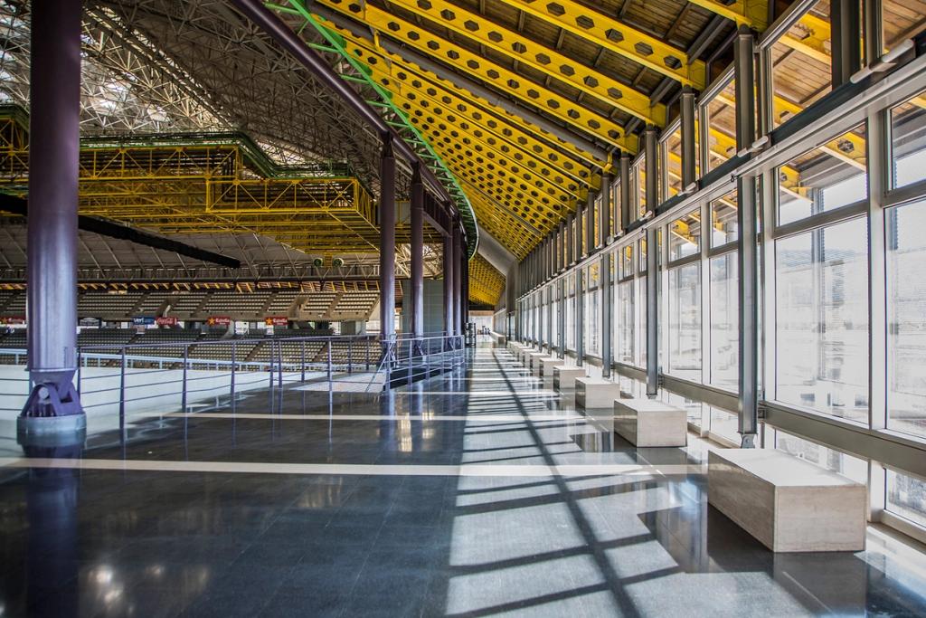 The glazed gallery of the Palau Sant Jordi, with yellow metal roof trusses
