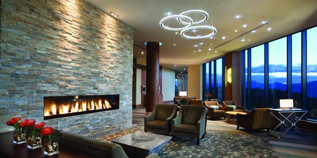 The Sparkling Hill lobby with a stone fireplace, crystal chandelier and views of the mountains