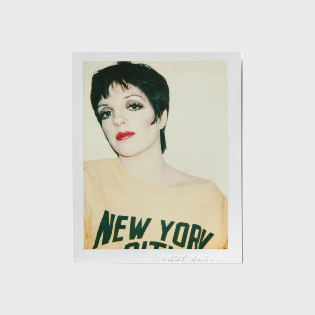 A Polaroid portrait of a woman with a short haircut wearing a yellow New York City T-shirt