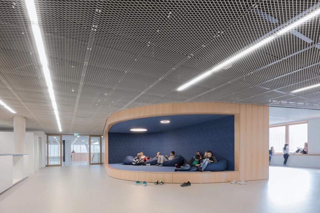 The rest area of Hessenwald school: a wooden niche with blue poufs beneath a mesh ceiling