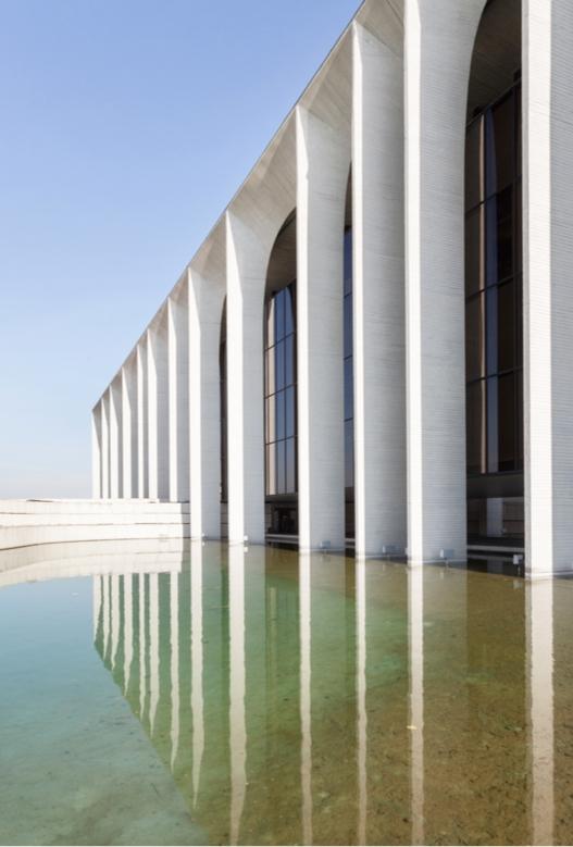 The arcade of the Mondadori building reflected in the mirror pool in front of the facade