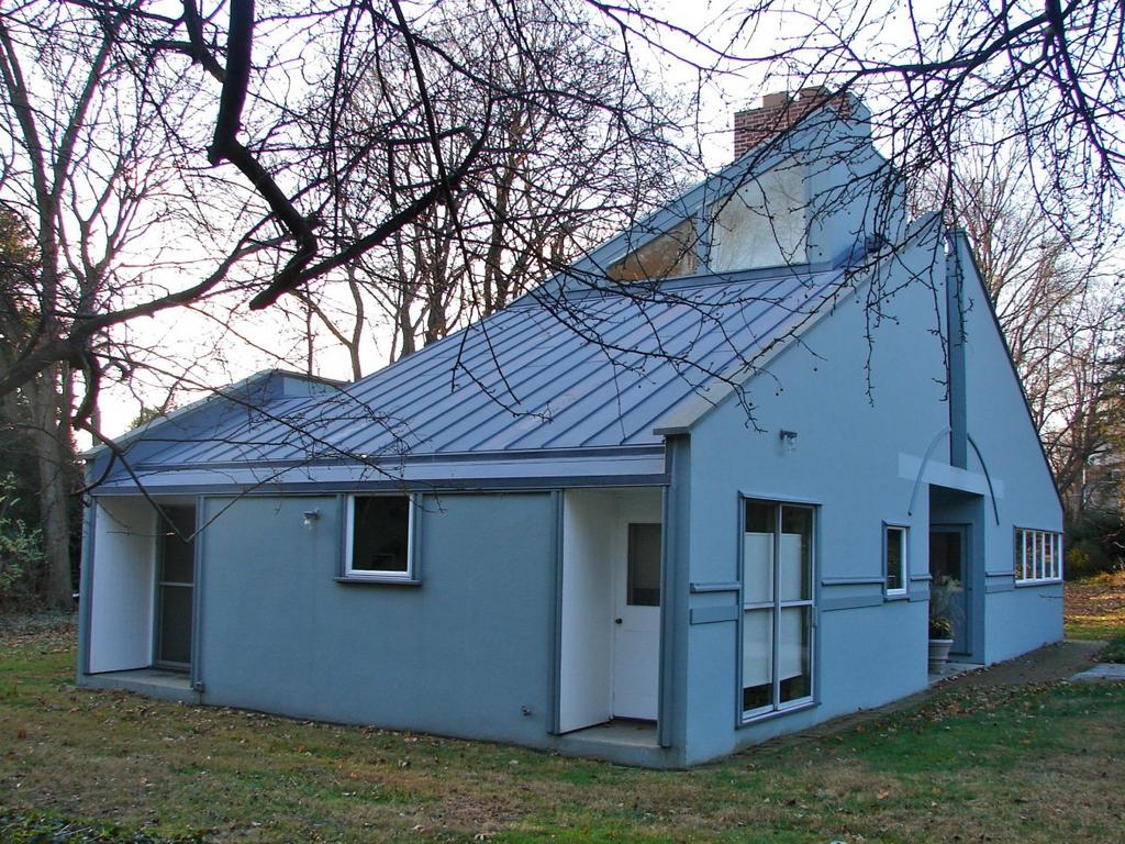 The blue Vanna Venturi House with a metal roof and brick chimney