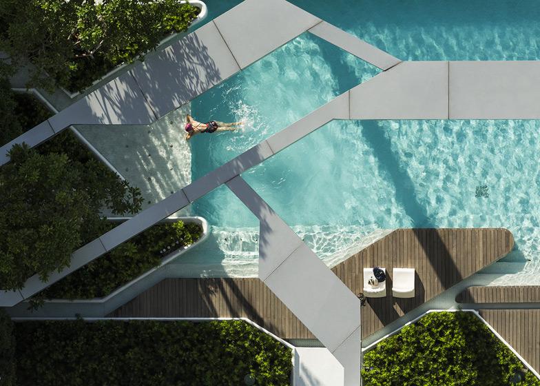 Вид сверху на лагунный бассейн The Pool at Pyne с пловцом и зеленью