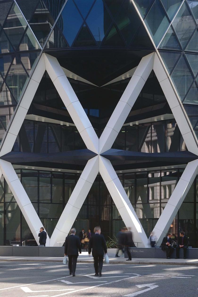 The entrance to 30 St Mary Axe, with its forked white V-shaped columns and people walking past