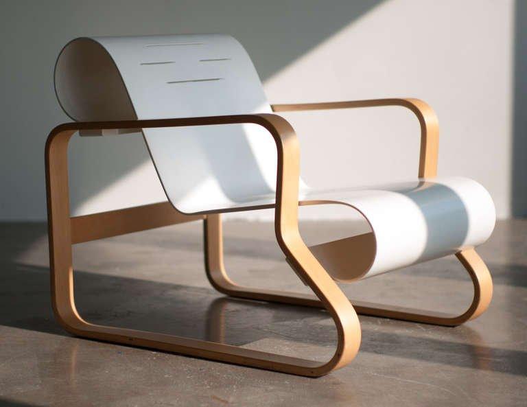 Alvar Aalto's Paimio Armchair, white bent seat on a birch plywood frame, three-quarter view