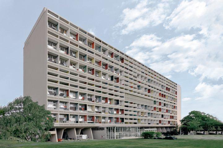 A long residential block in Berlin with coloured loggias raised on concrete pilotis