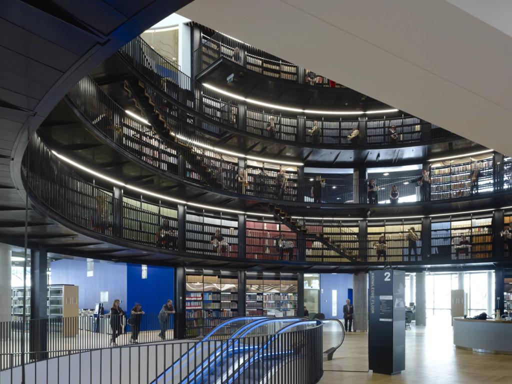 The circular black atrium of the Library of Birmingham, with tiered bookshelves and a spiral staircase