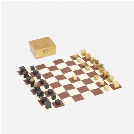 The Hartwig chess pieces set up on the folded board beside the wooden box