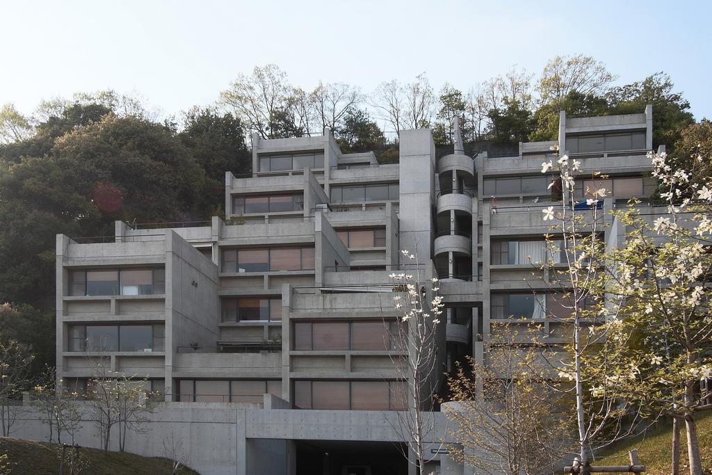 A stepped concrete residential complex on a hillside, architect Tadao Ando