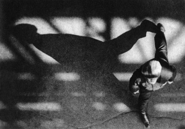 A running figure photographed from above, casting a long diagonal shadow