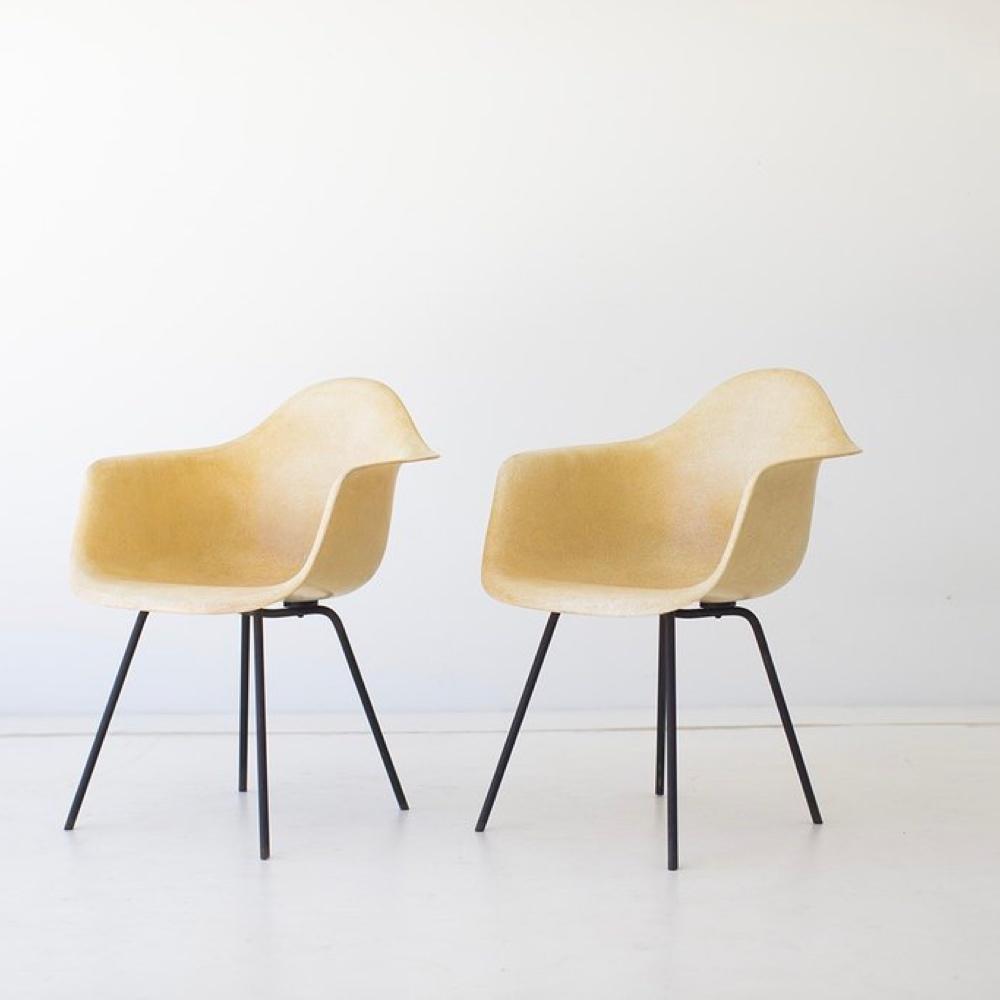 A pair of Eames chairs in light fibreglass on black metal legs