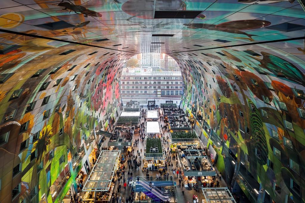 The painted vault of the Markthal interior, with market stalls and a view of the city through the glass