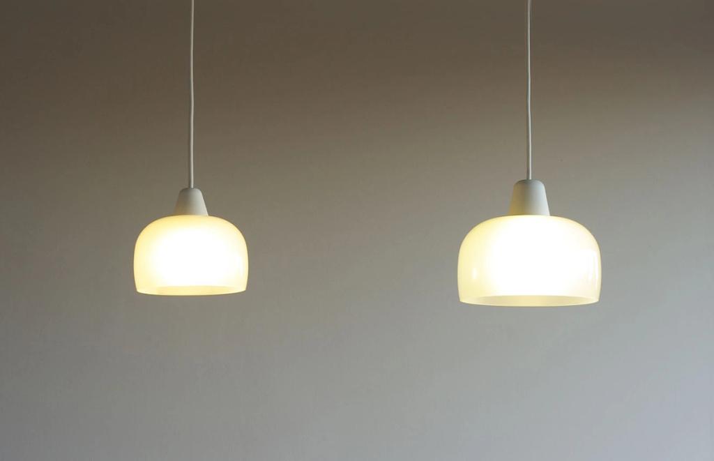 Two white matte pendant lights with a warm glow