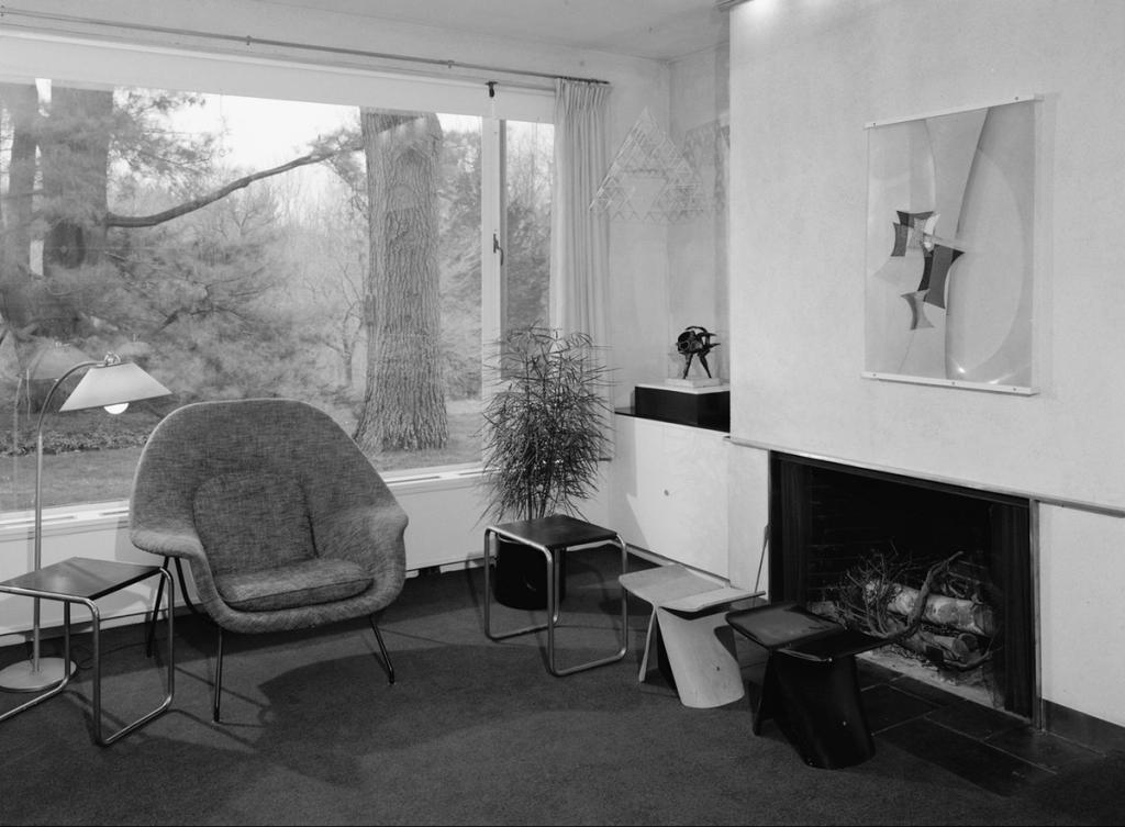 The living room of the Gropius House with a Womb chair, a fireplace and an abstract painting
