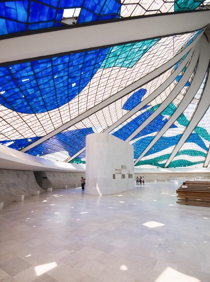 The bright hall of Brasília Cathedral beneath a blue-green stained-glass vault
