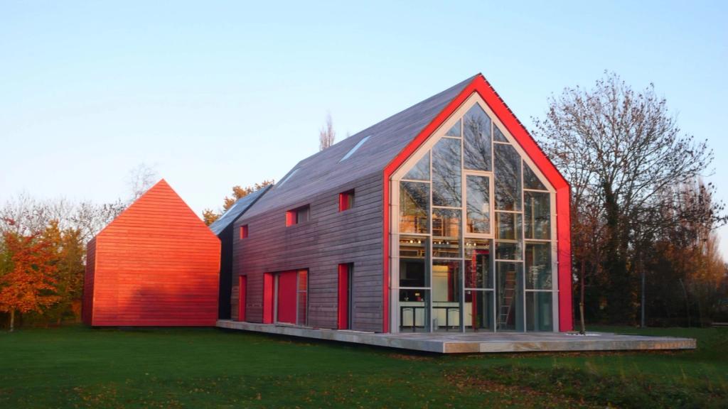 The dRMM Sliding House with its timber and red sections at sunset