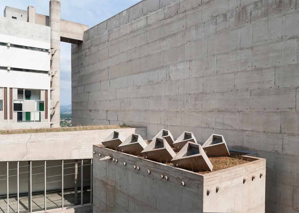 The refectory of La Tourette Monastery with concrete columns and green and red curtains