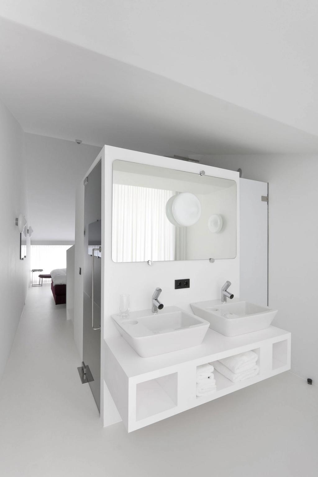 Белый минималистичный номер Hotel Zenden с антресолью, вешалкой и комодом