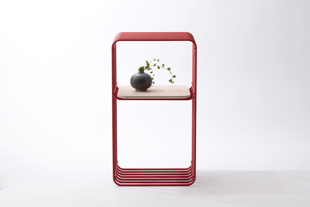 Red metal side table with shelves and a dark vase