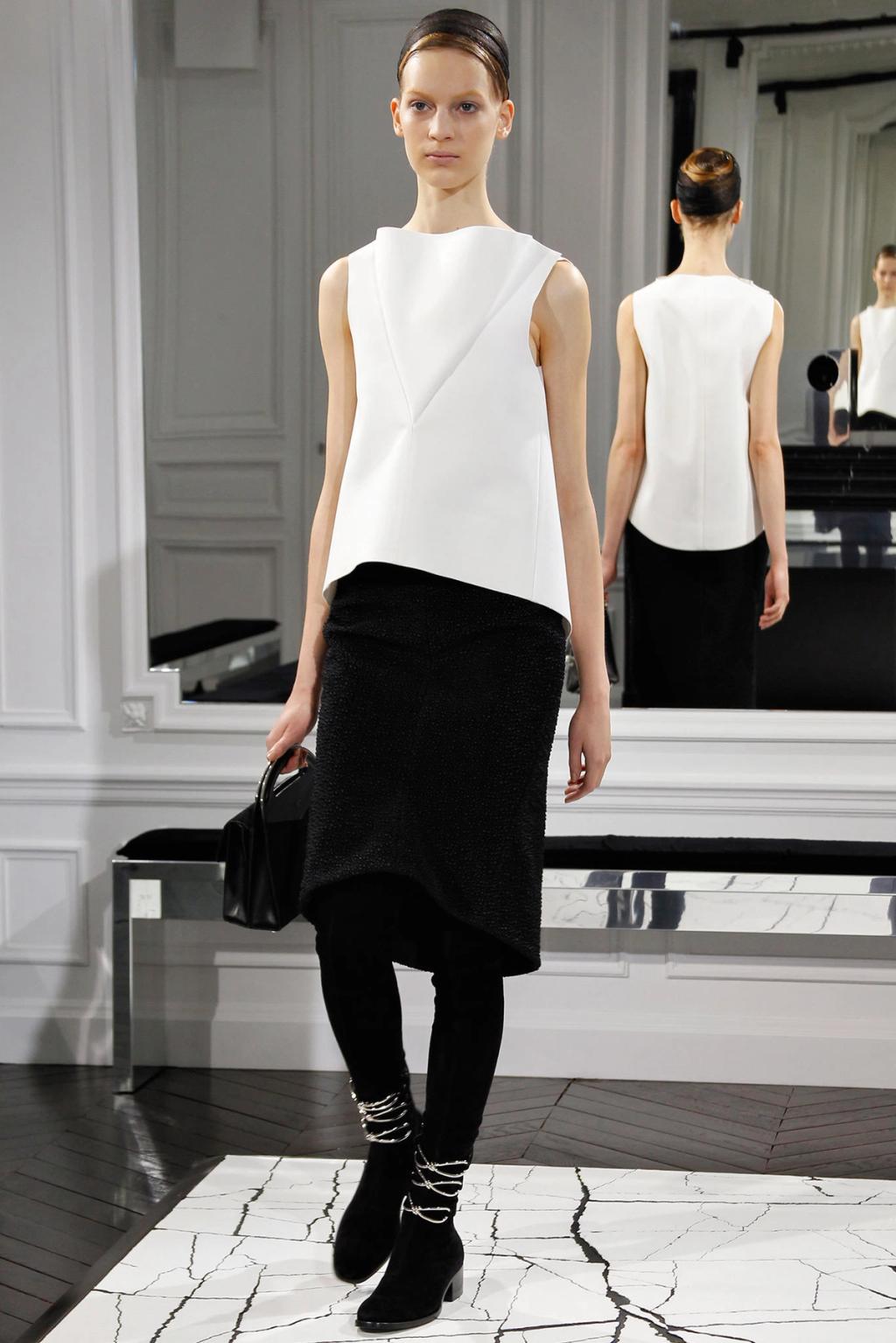 Balenciaga show: a model in a white top and black skirt with lace-up ankle boots