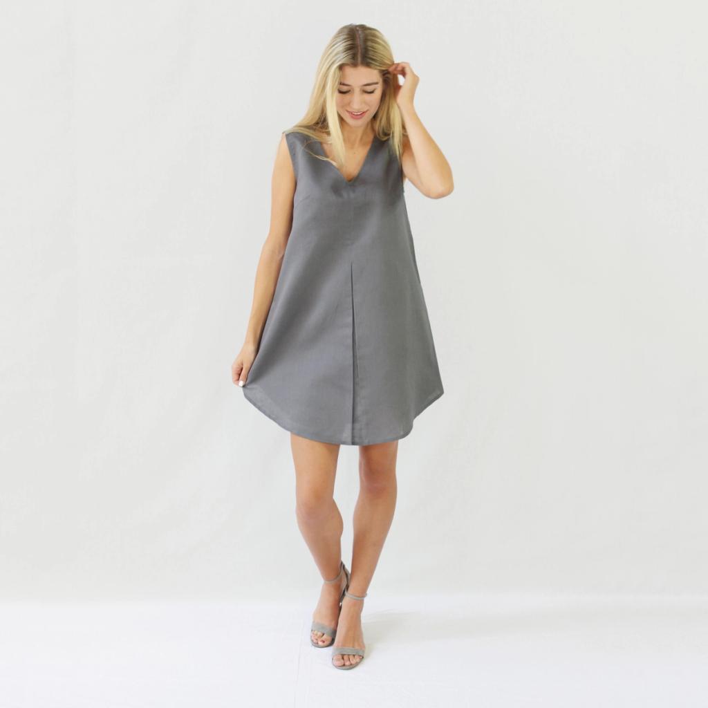 A model in a grey sleeveless minimalist Kestan dress and sandals