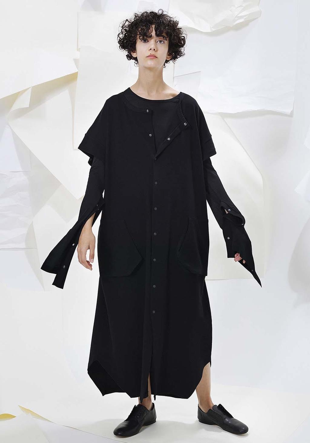 A model in a long black shirt-dress with asymmetric sleeves