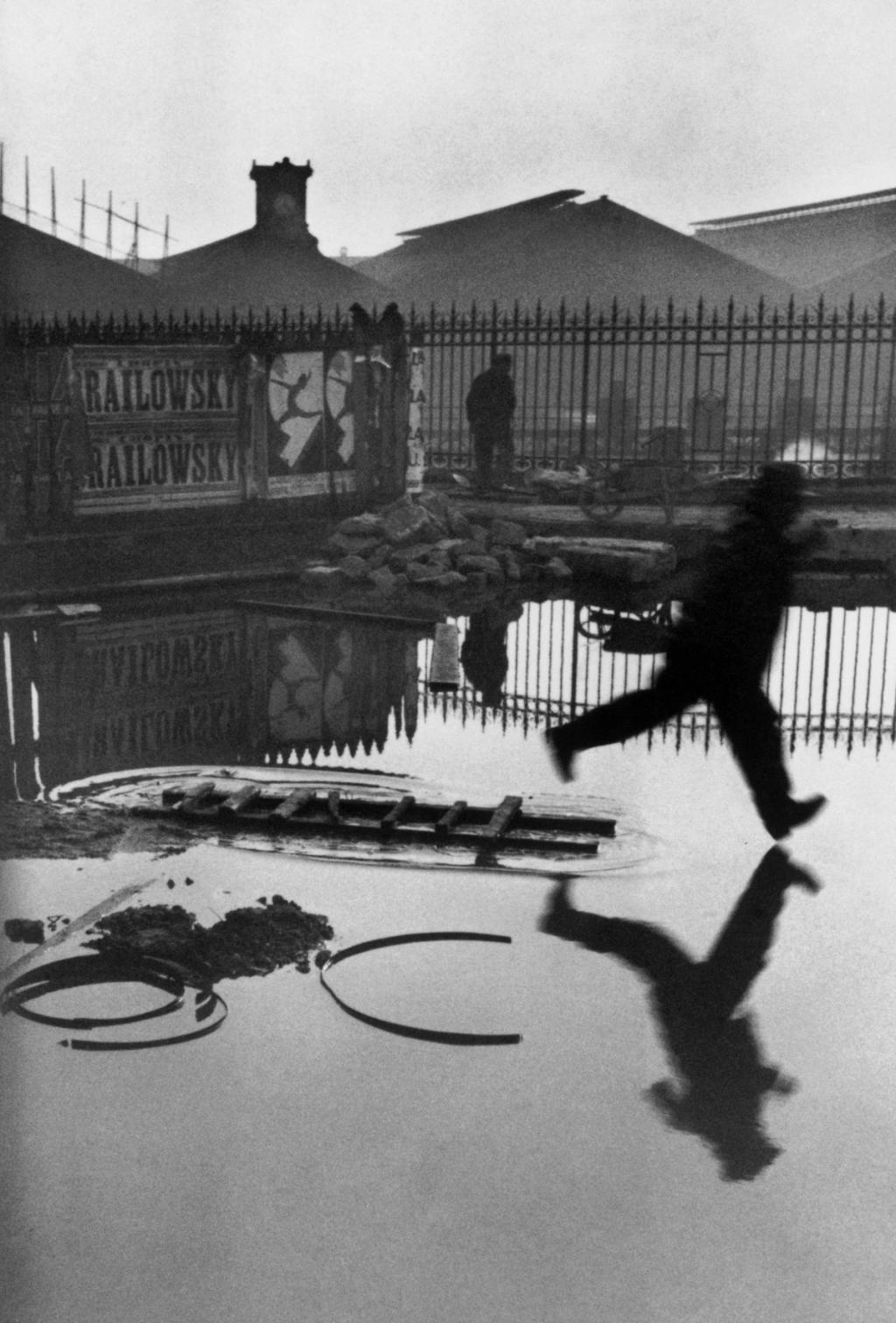 The famous photograph of a man leaping over a puddle behind the Gare Saint-Lazare in Paris
